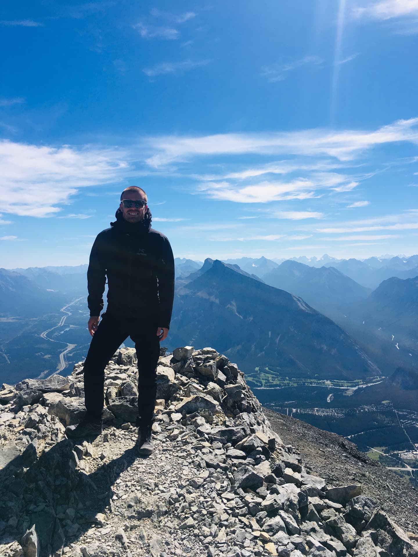 Robin standing on a rocky summit above the Canadian Rockies