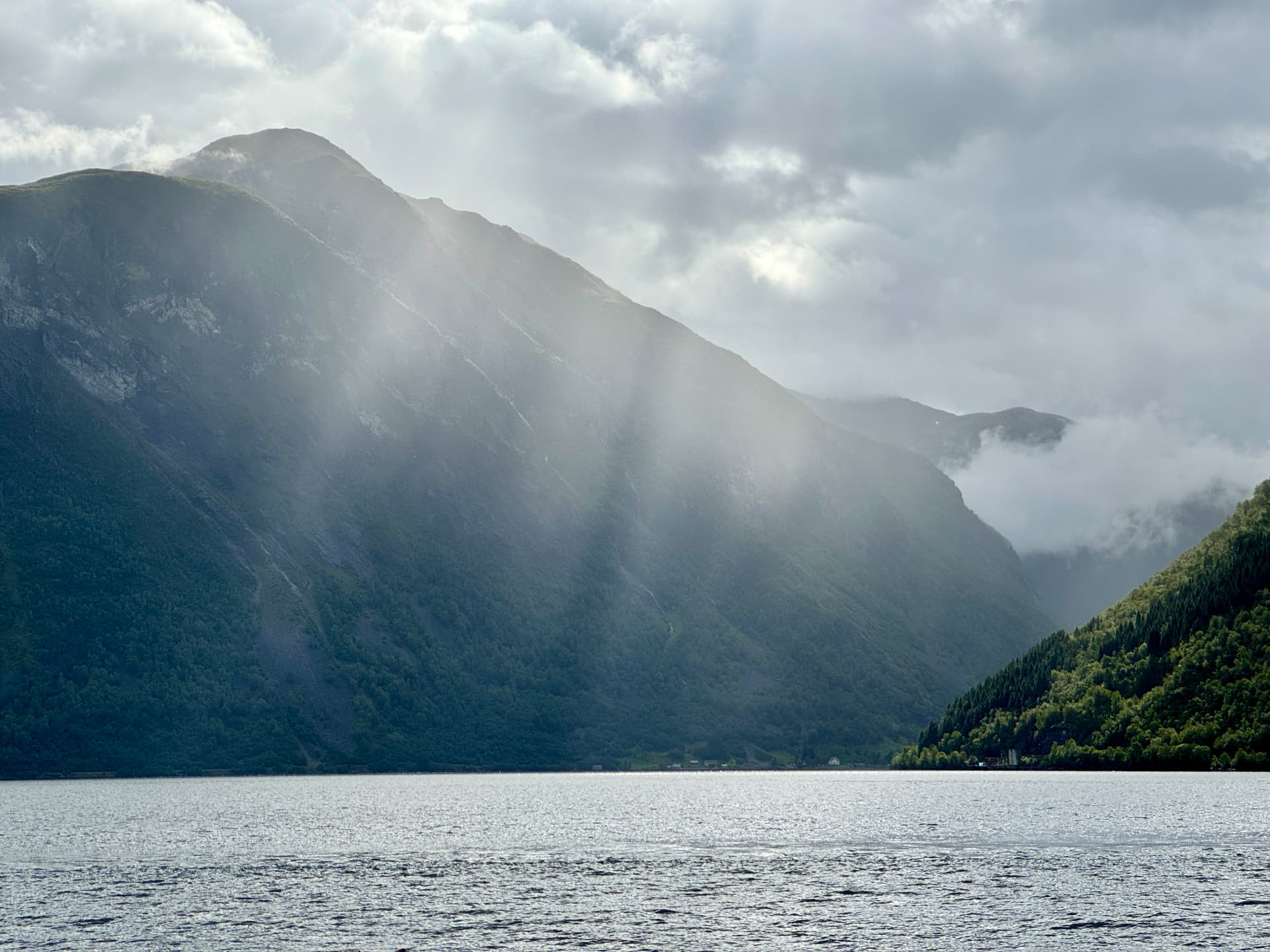 Sunlight crossing a still Norwegian fjord