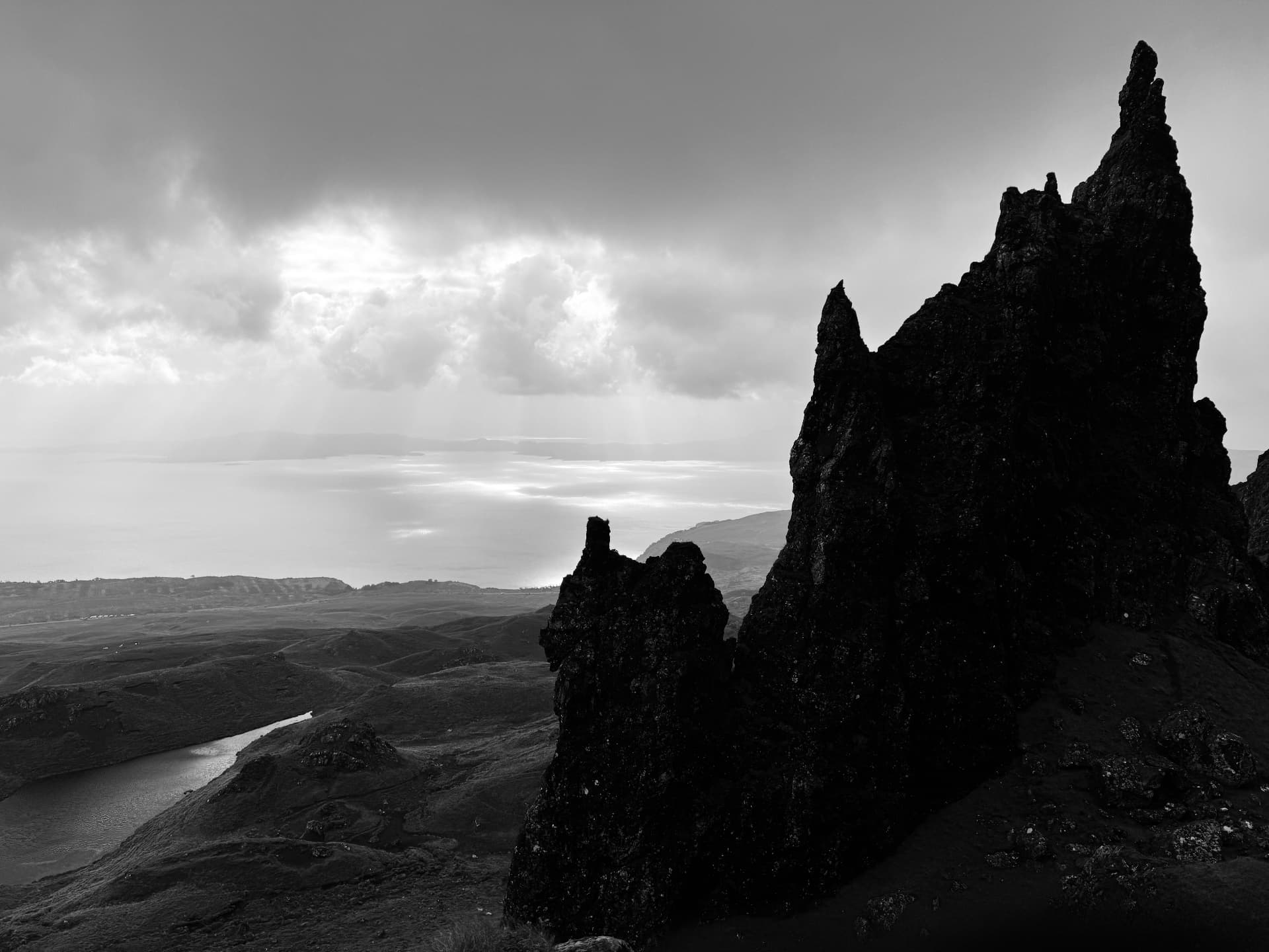 Dark rock pinnacles beneath a breaking sky